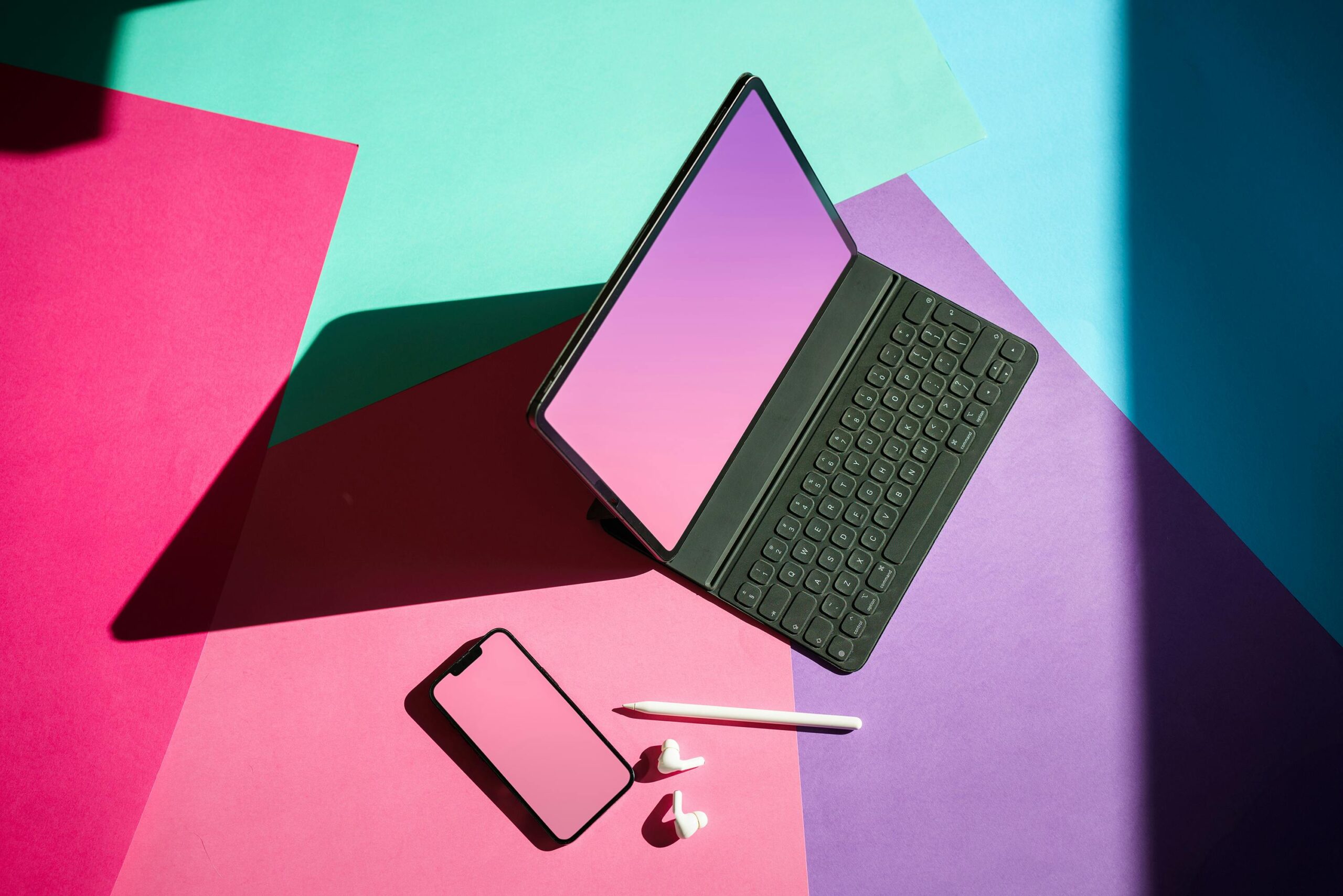 Services Vibrant flat lay featuring a tablet, smartphone, and stylus on a colorful background.